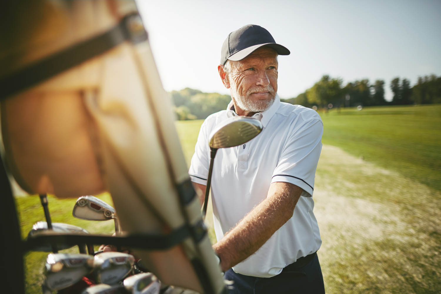 Senior man preparing to play golf on a sunny day
