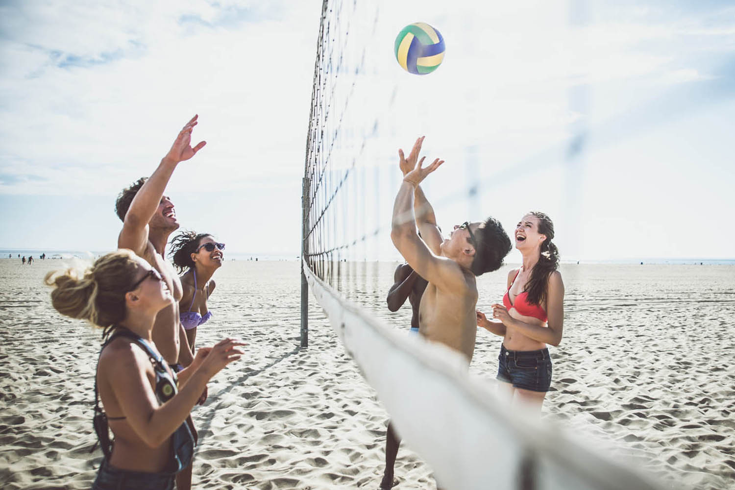 young people playing beach volleyball